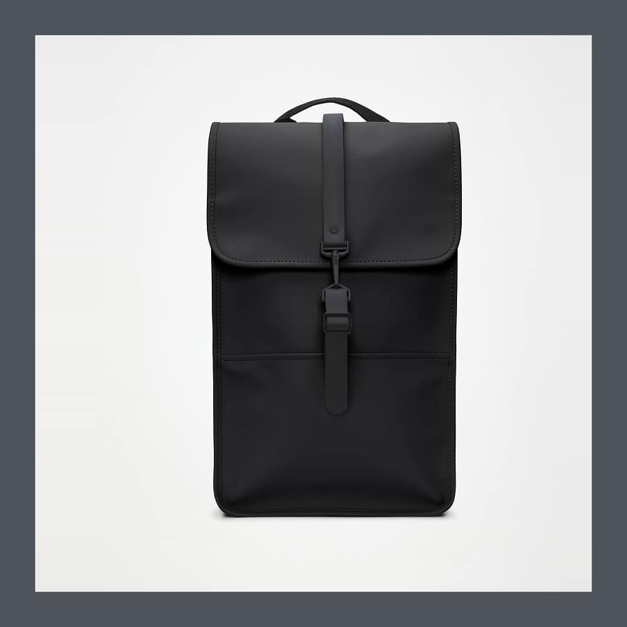 The black Rains Backpack photographed front on, showing the flap and hook closure