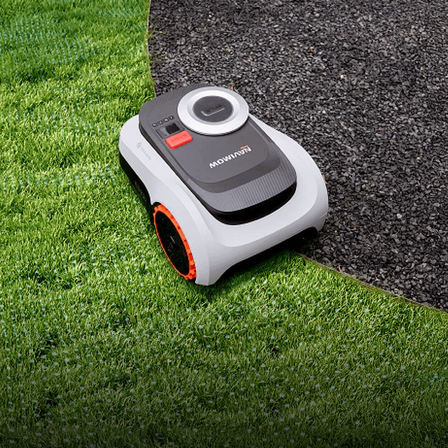 Segway Navimow i208 LiDAR robot lawnmower cutting a lawn beside a gravel path and metal edging