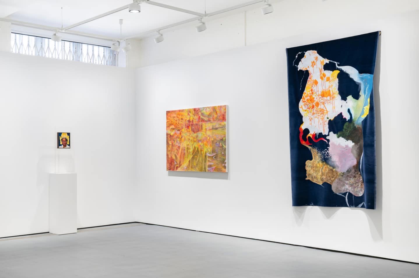 A small portrait on a plinth, Yuchen Zhan's orange painting Otherworld and Lucy Grant's large painted velvet Blue Velvet Three