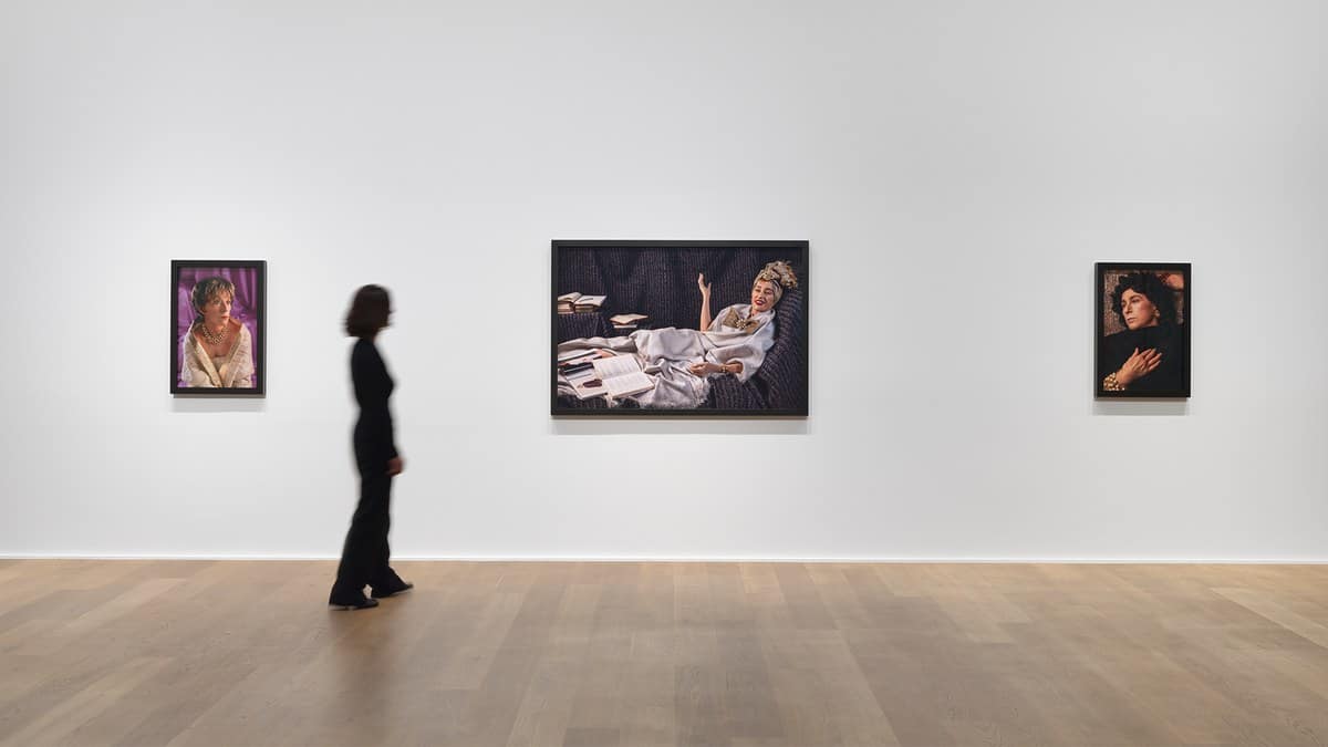 Gallery wall at Hauser & Wirth London with three Cindy Sherman photographs and a visitor walking past