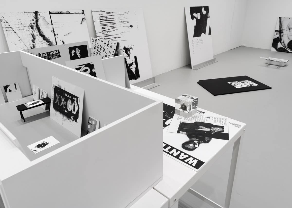 Cady Noland installation at Gagosian Davies Street with black and white printed panels, a low partition wall and a table