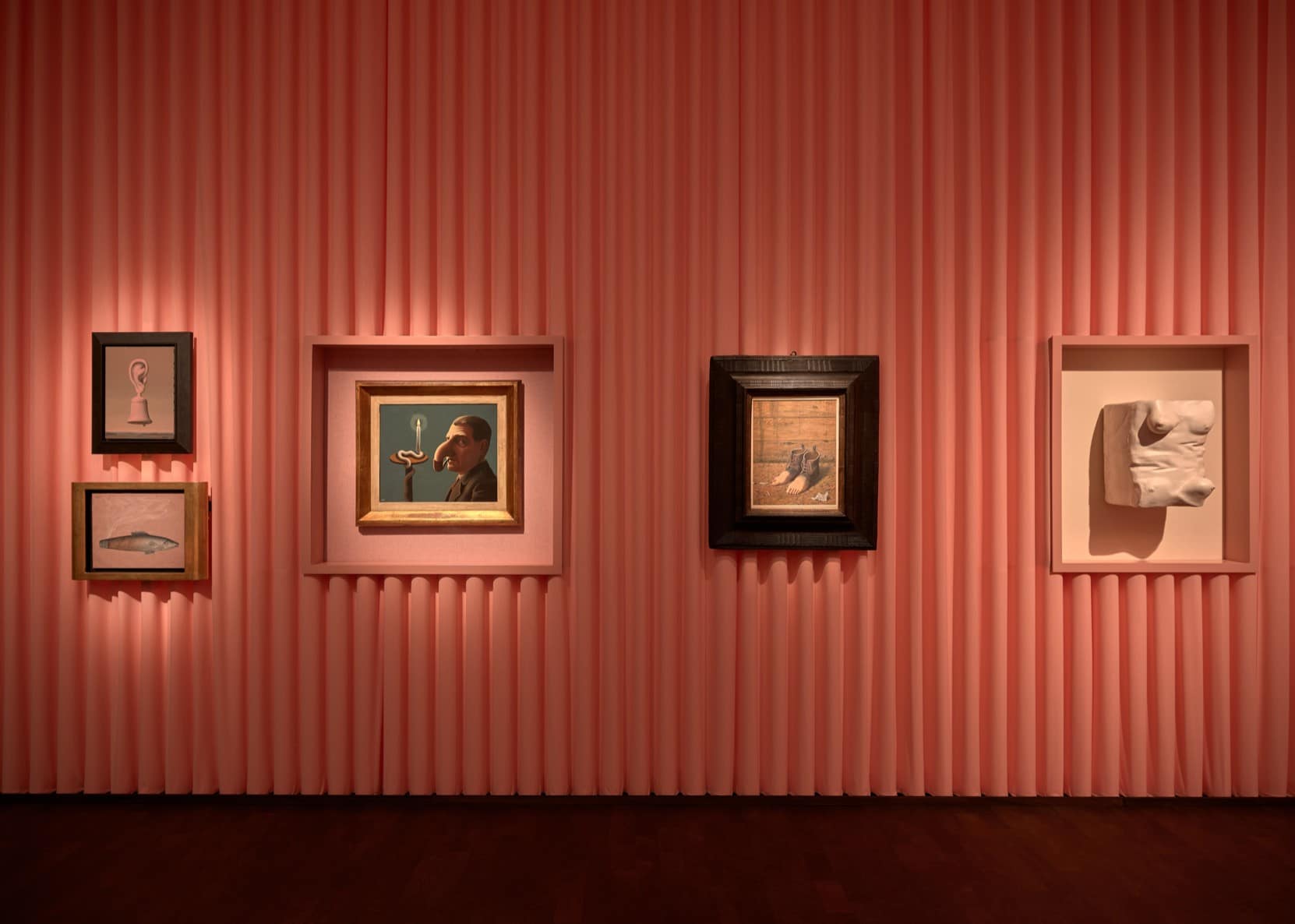 Pink pleated curtain wall with La Lampe philosophique and other Magritte works, and a Robert Gober torso