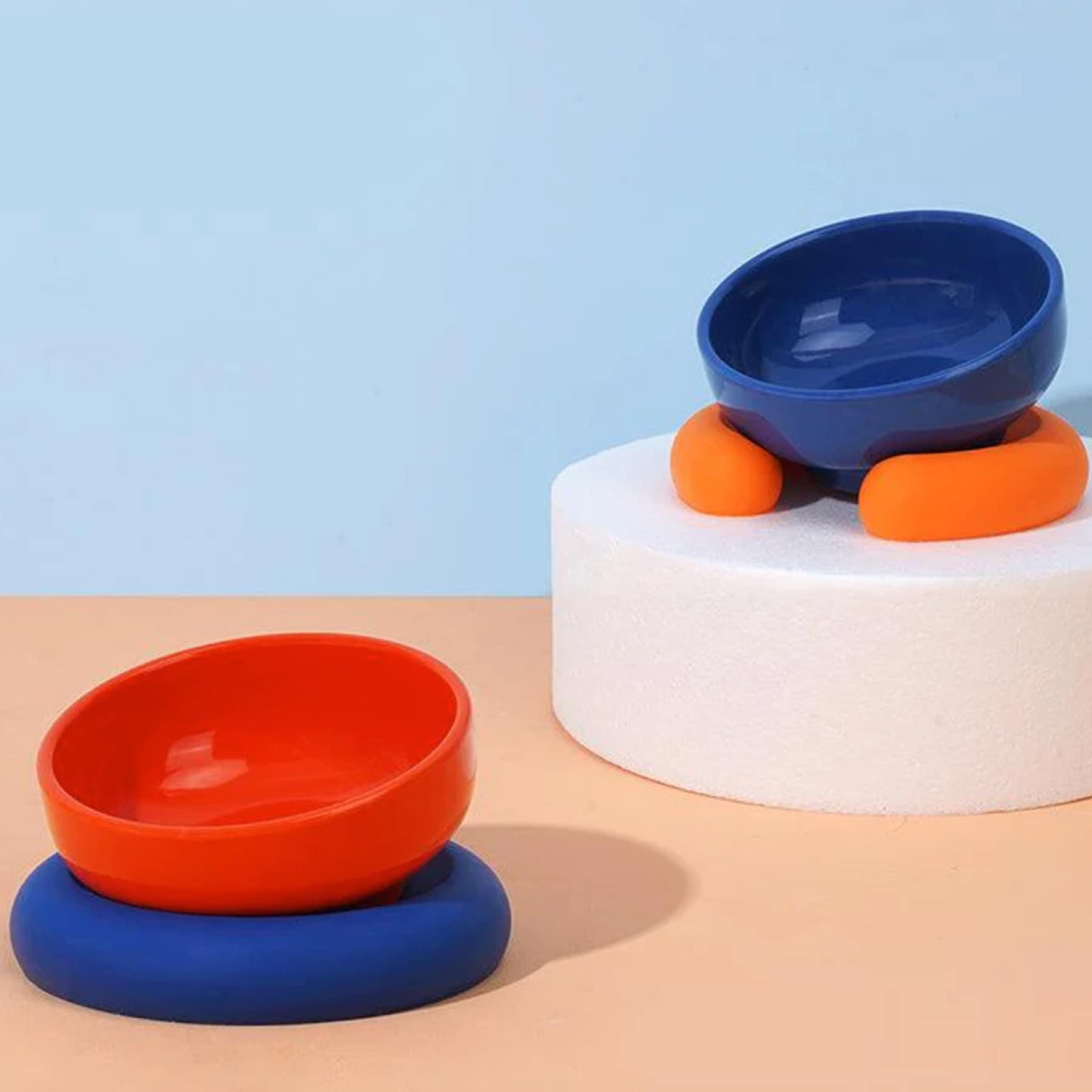 Colourful raised cat bowls in orange, red and blue with tilted ergonomic design
