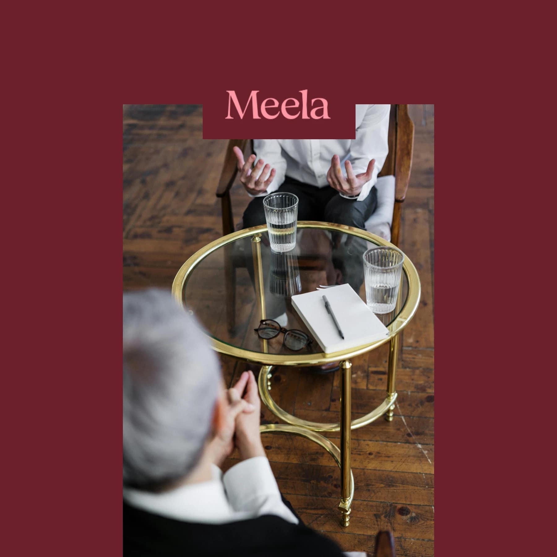 Two people having a therapy session with glasses of water and notepad on table, Meela logo above.