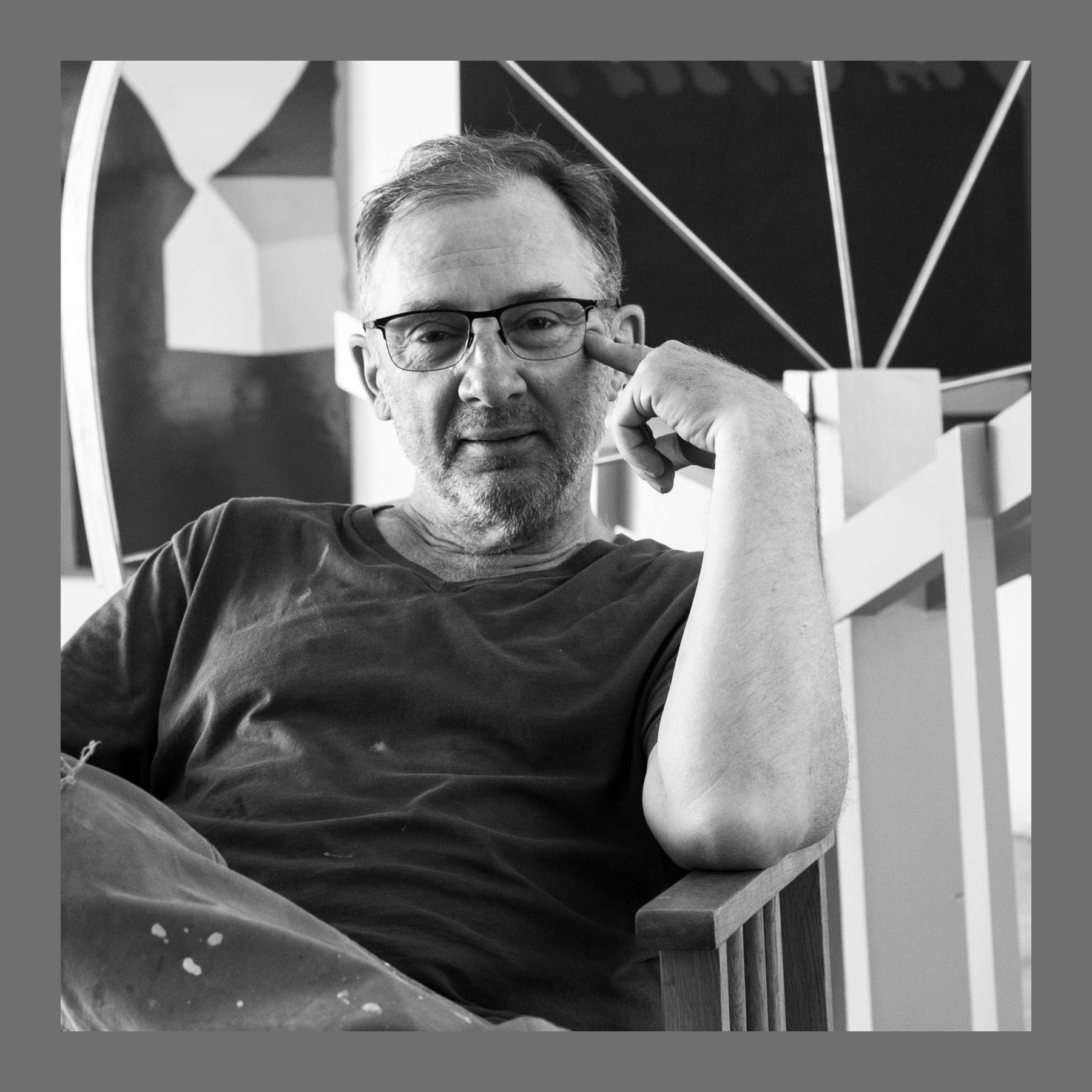 Black and white photo of Gary Hume seated in his studio