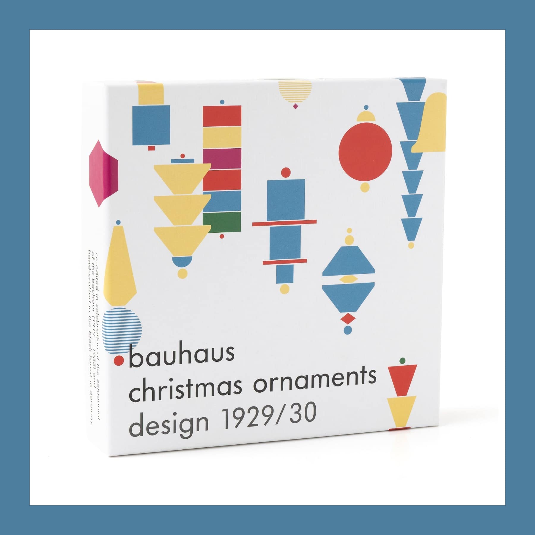 Gift box of Bauhaus Christmas ornaments printed with red, yellow and blue geometric shapes