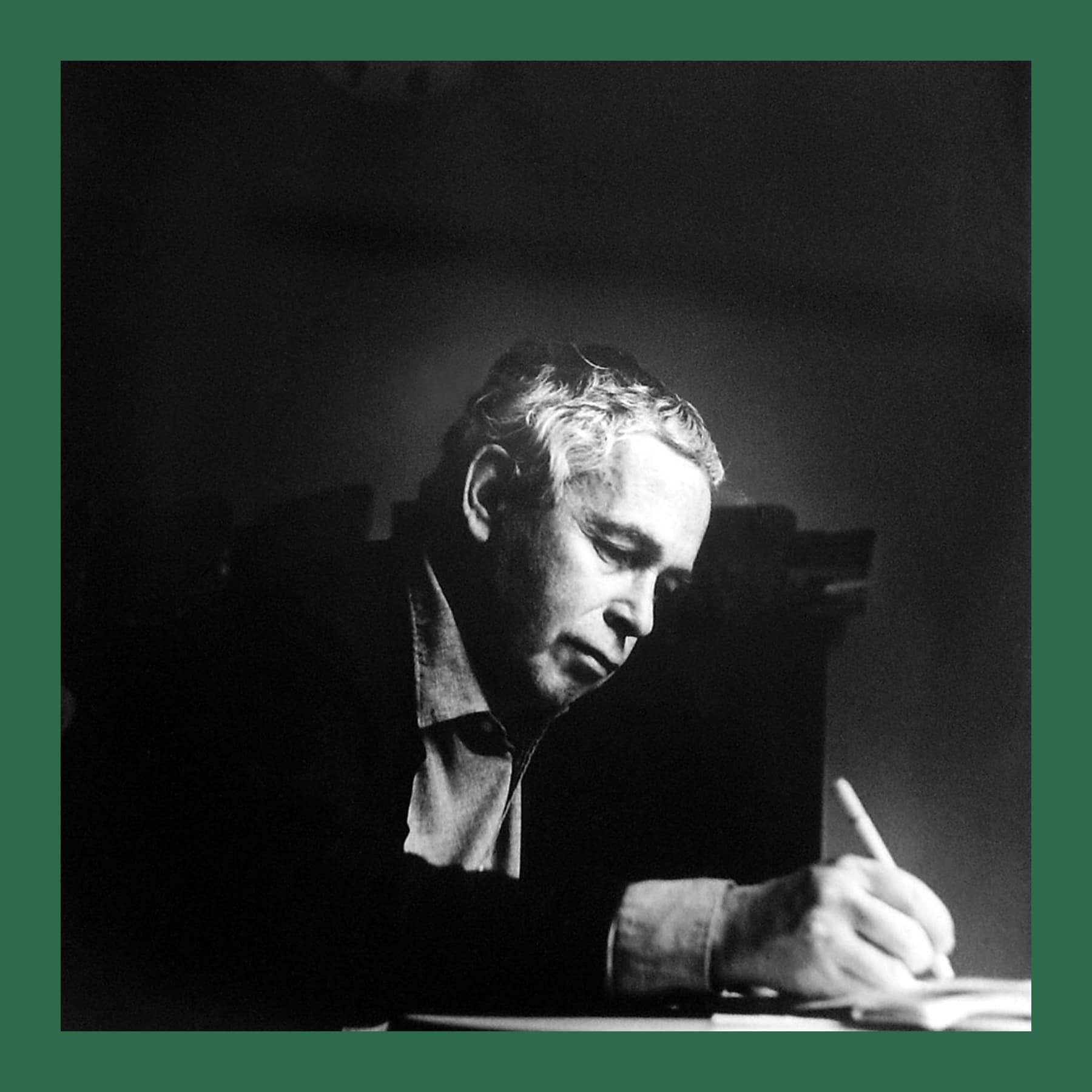 Black and white photograph of the painter Howard Hodgkin in 1987, seated and writing at a desk