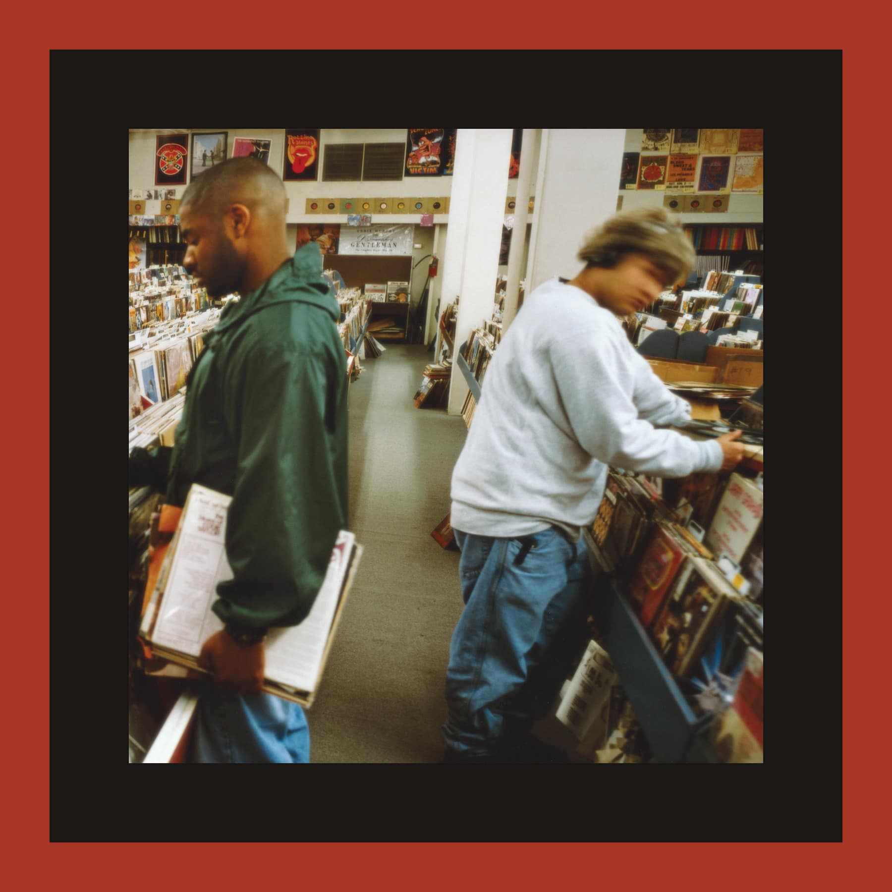 DJ Shadow Endtroducing sleeve: two men browsing the racks of a record shop, one carrying a stack of LPs