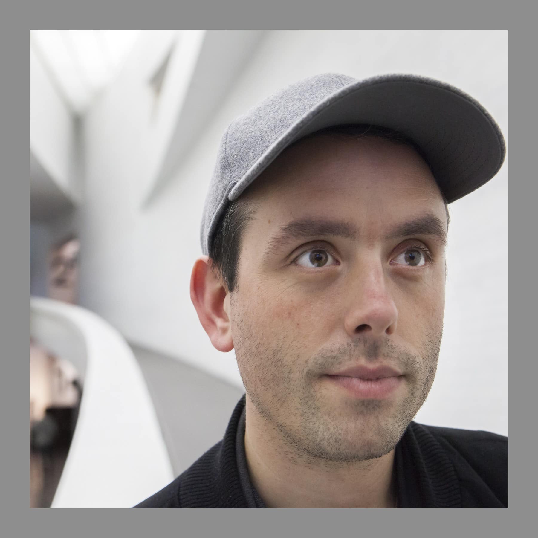Close-up of Ed Atkins in a grey cap inside Kiasma, Helsinki