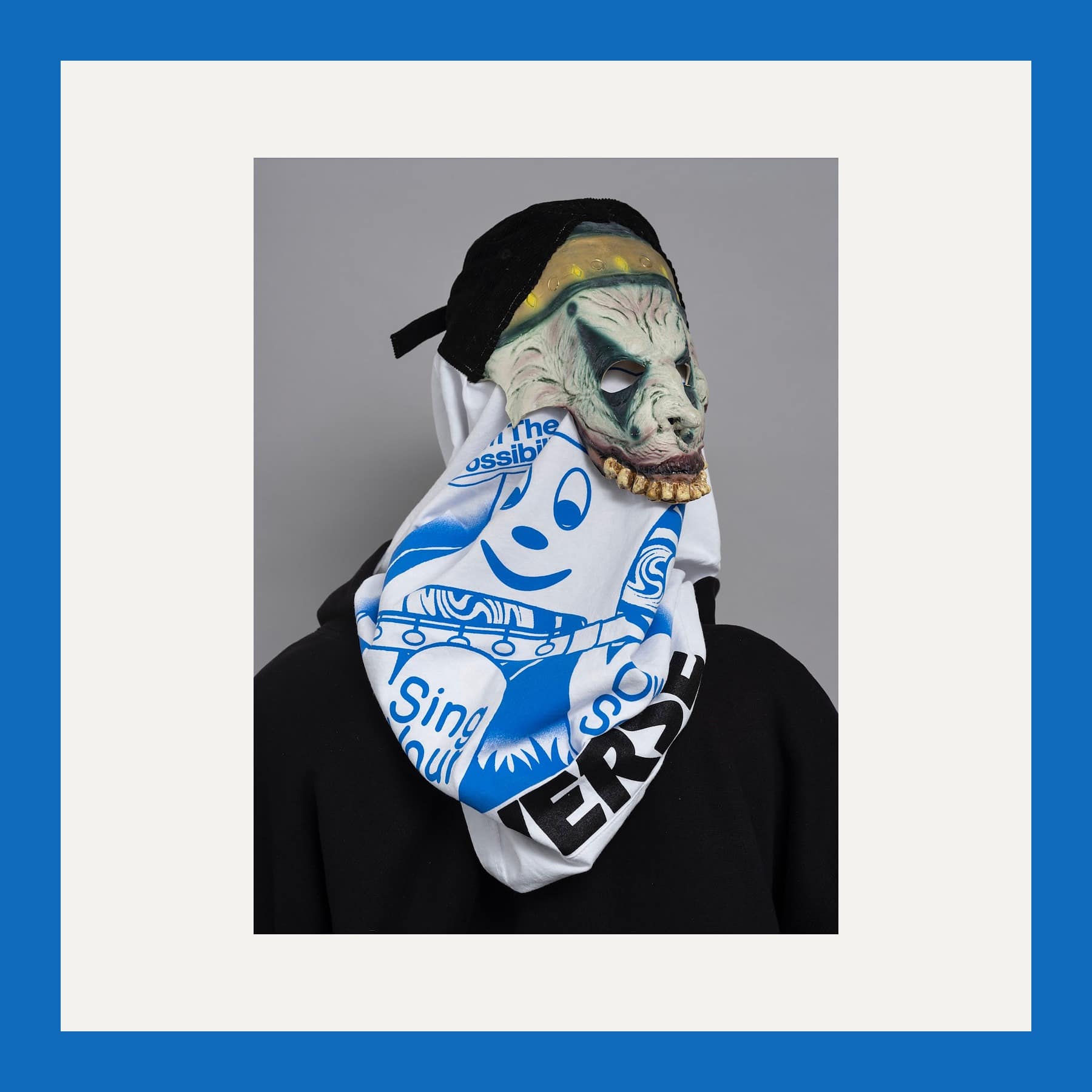 R.I.P. Germain print Cracky Blackz's Genie: a figure from behind in a black hoodie, a printed white top and a rubber mask