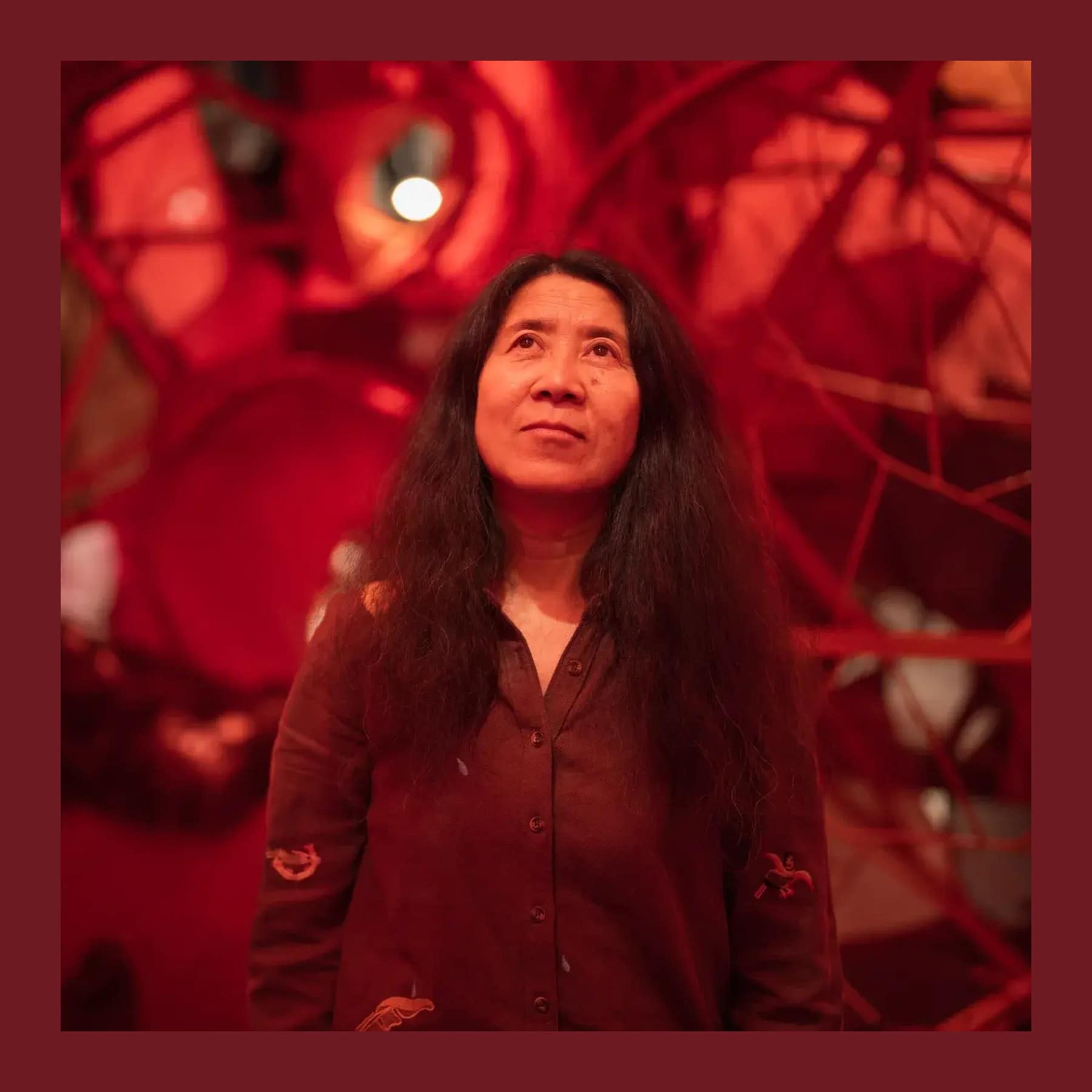 Yin Xiuzhen looking up inside her red walk-in heart sculpture at the Hayward Gallery