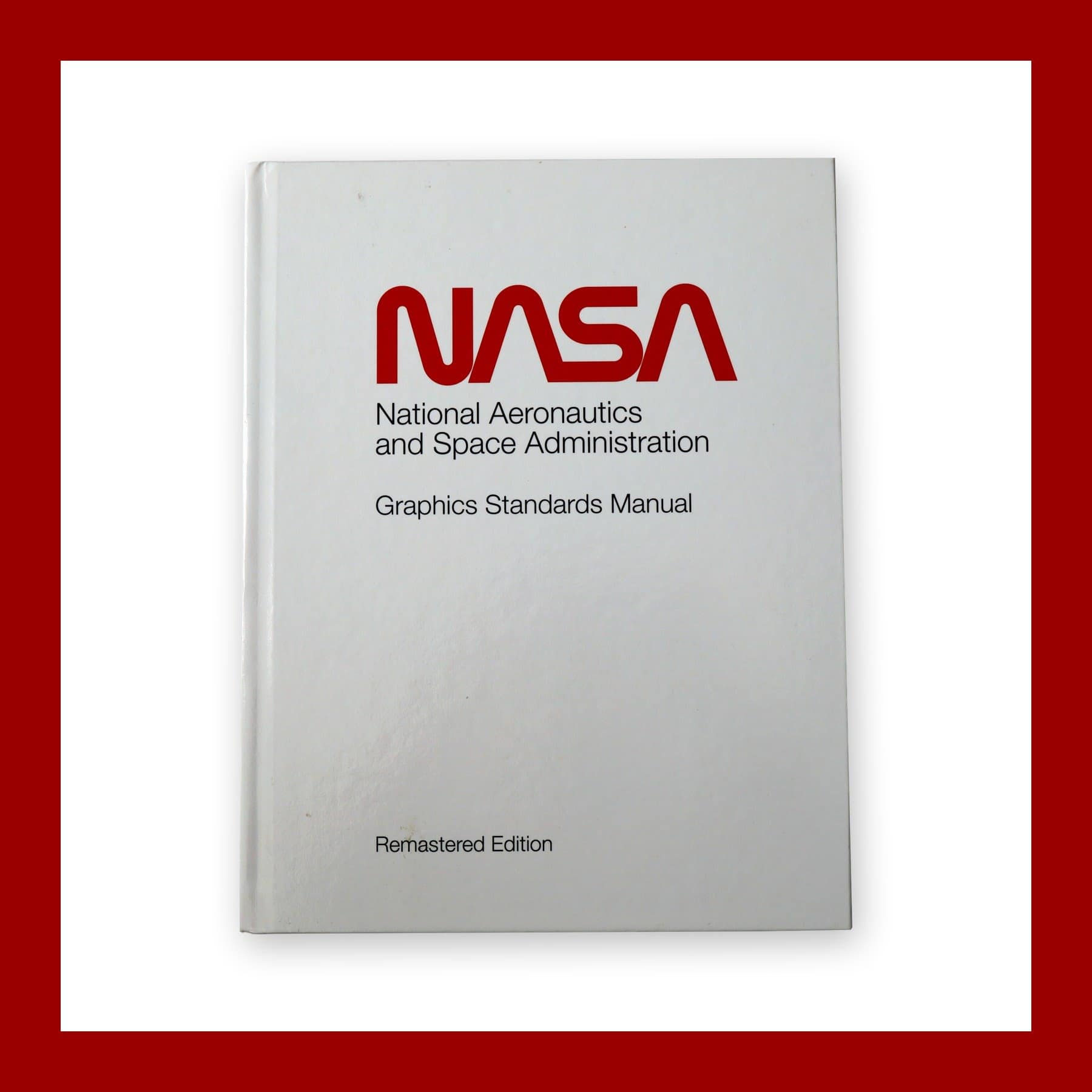 White hardback cover of the NASA Graphics Standards Manual Remastered Edition with the red NASA worm logo