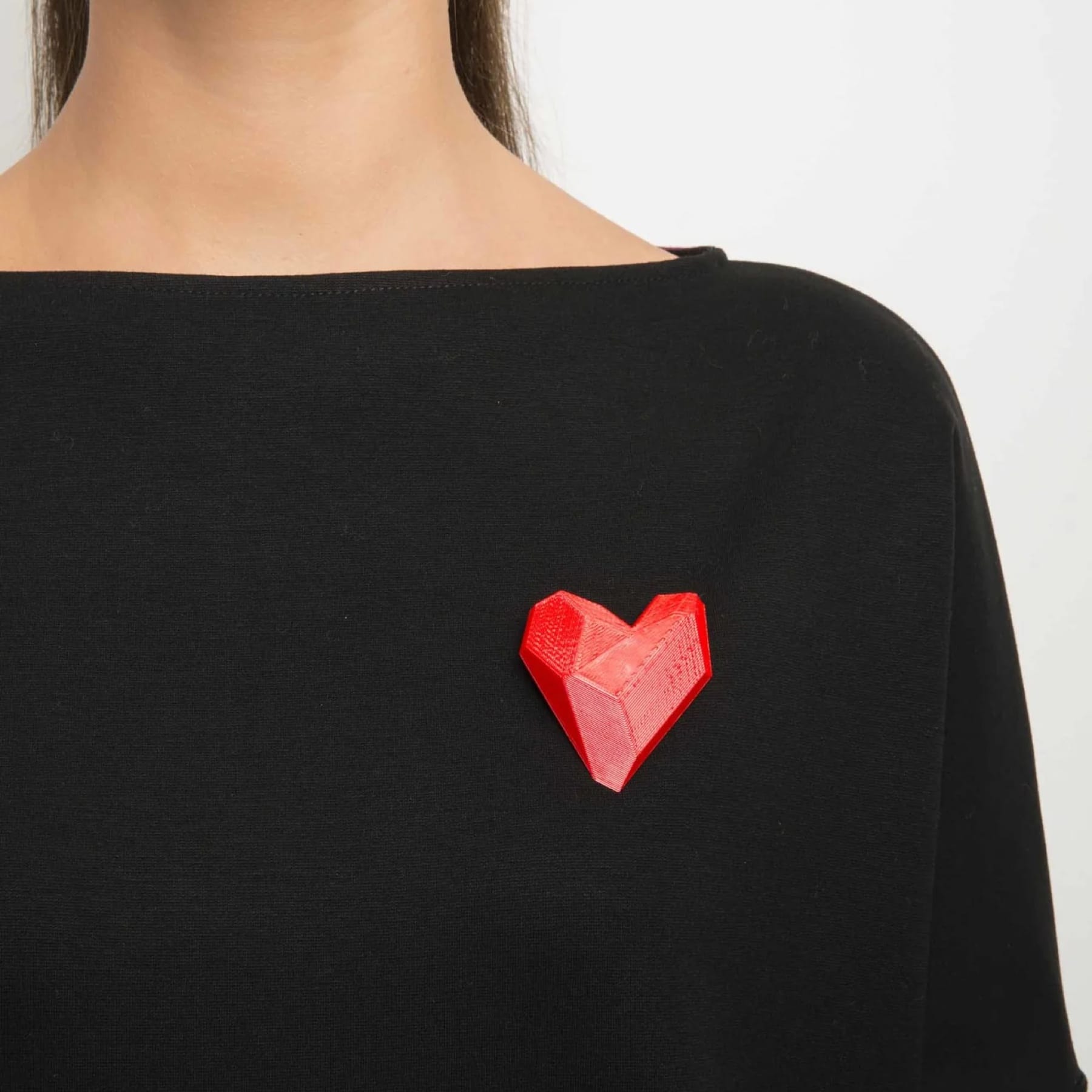 Red 3D-printed heart brooch by Maison 203 worn on a black top.