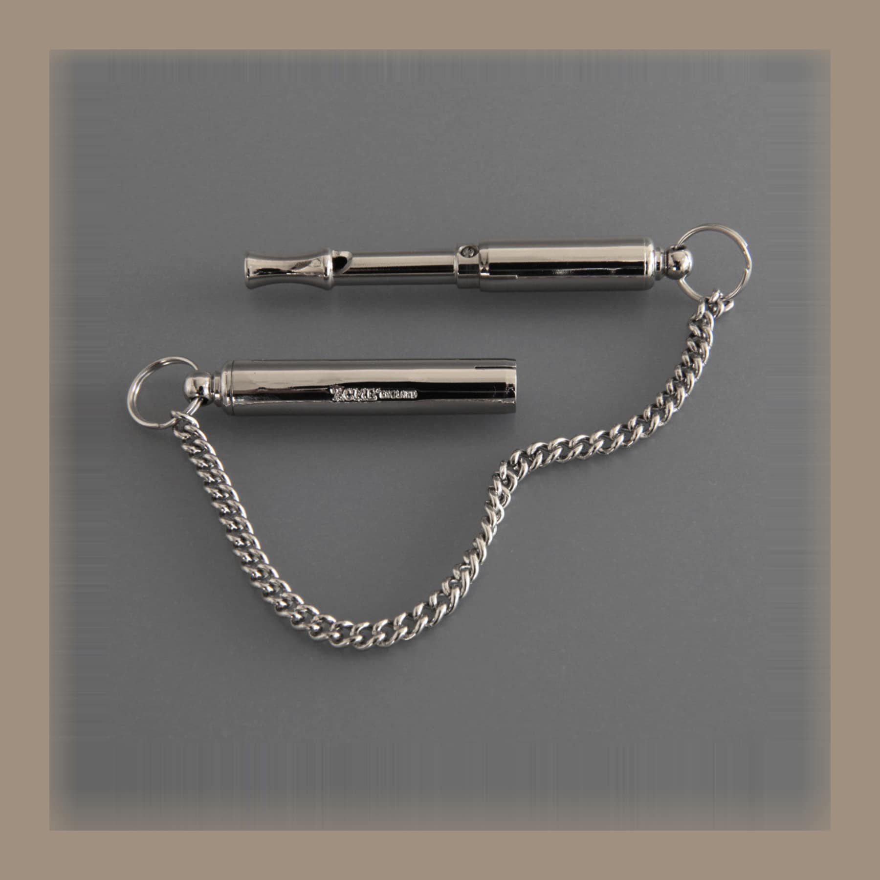 Two nickel-plated Acme silent dog whistles with an adjustable threaded end and a chain