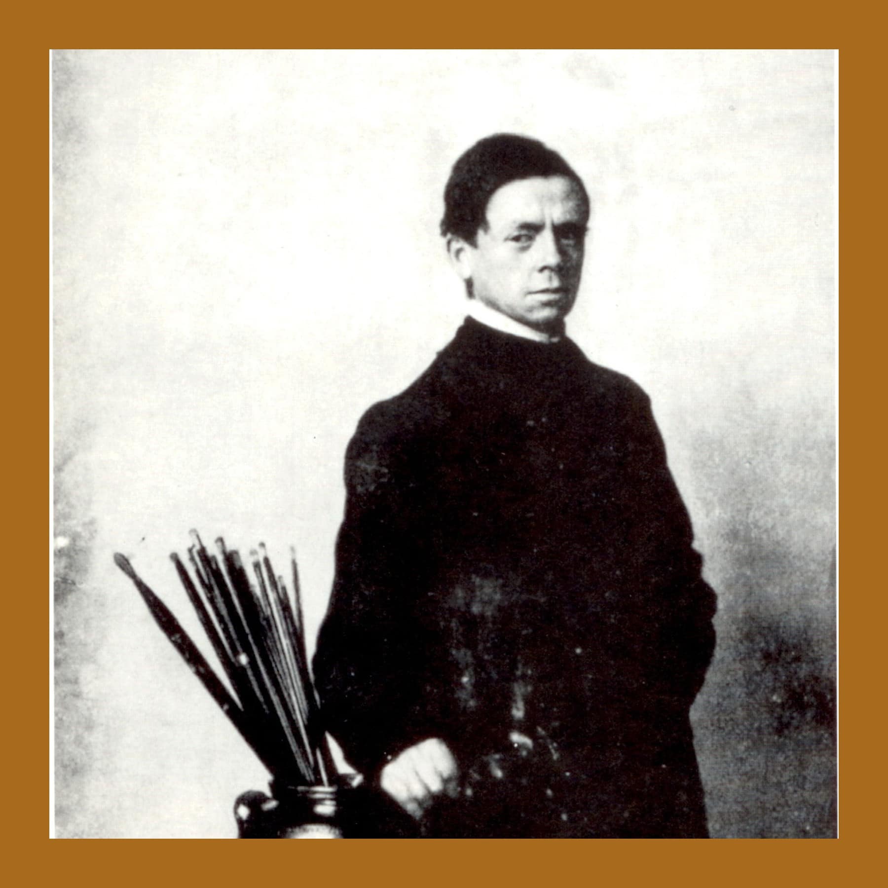 William Nicholson in 1912, standing in a dark coat beside a jar of paintbrushes