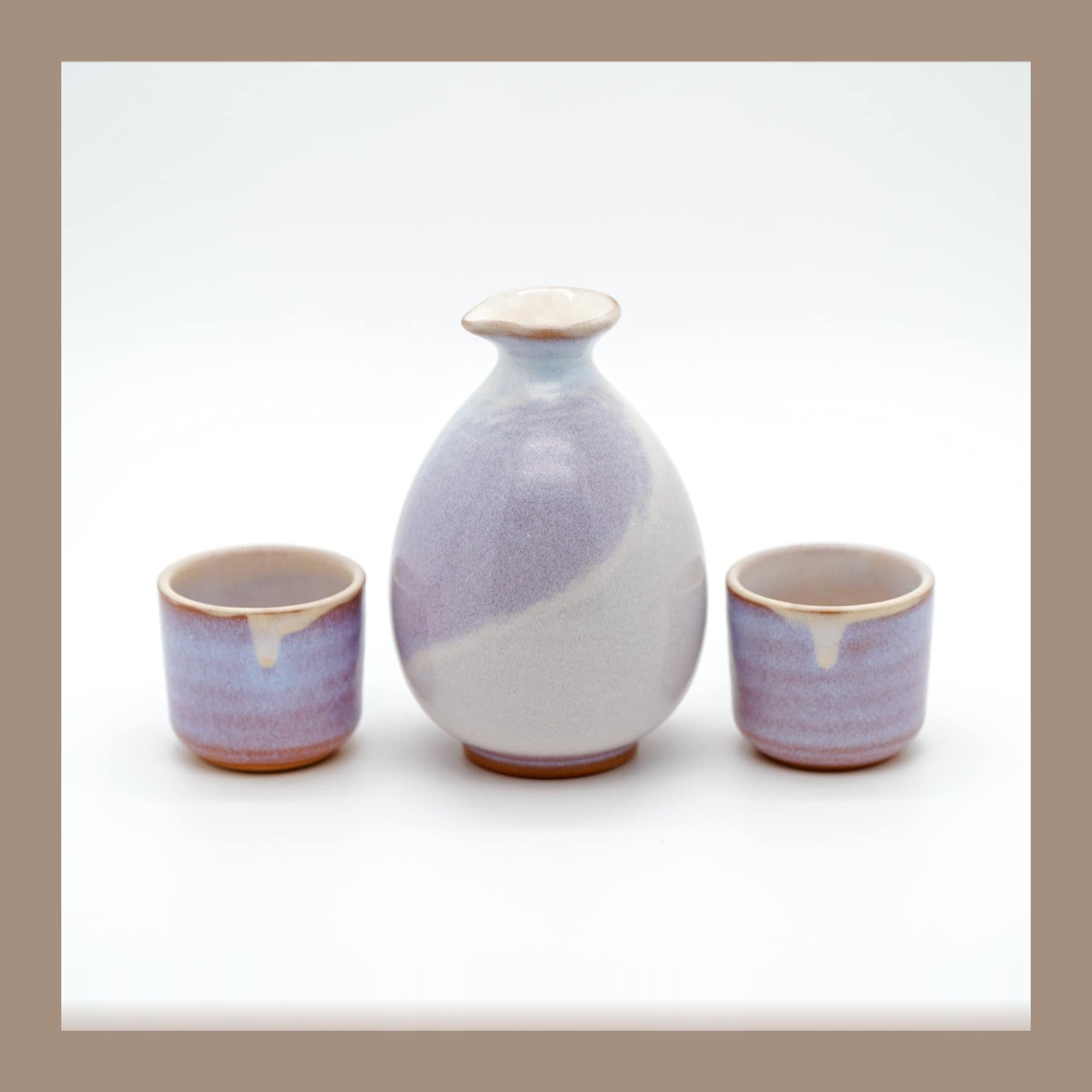 Hagi ware sake set with a lavender and cream glazed carafe and two matching cups