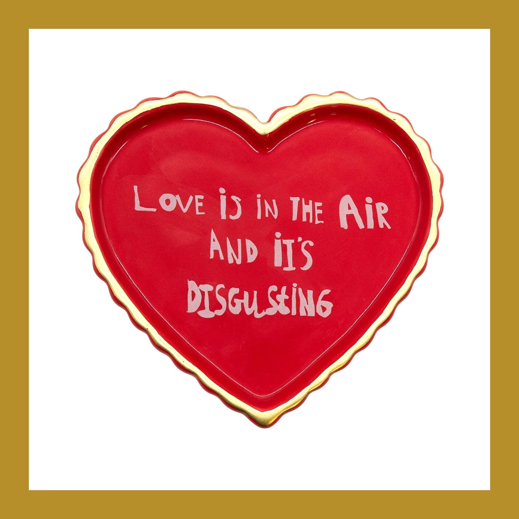 Red heart-shaped ceramic trinket tray with a gold rim, hand lettered Love is in the Air and it's Disgusting