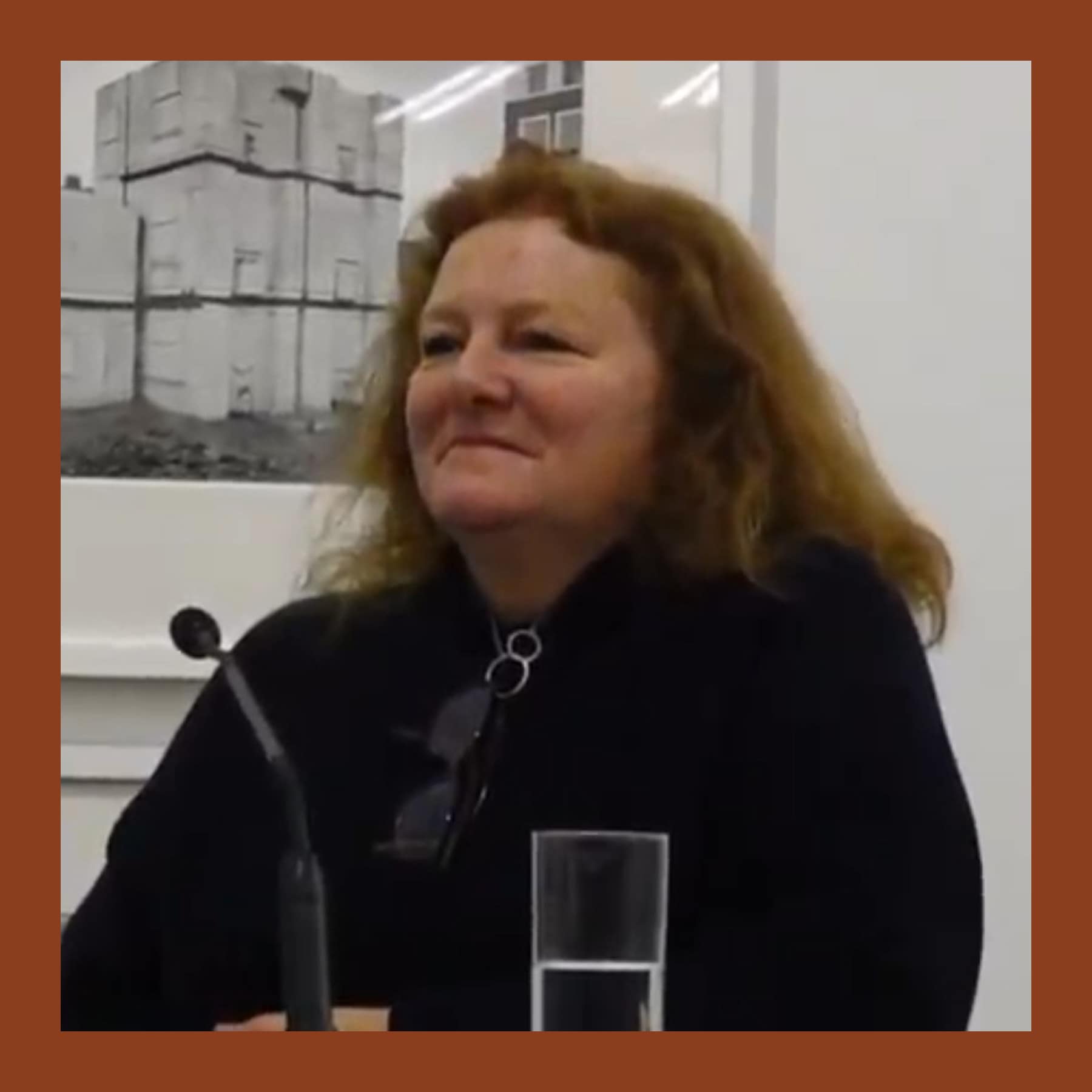Rachel Whiteread with auburn hair and a dark top, speaking at a press conference