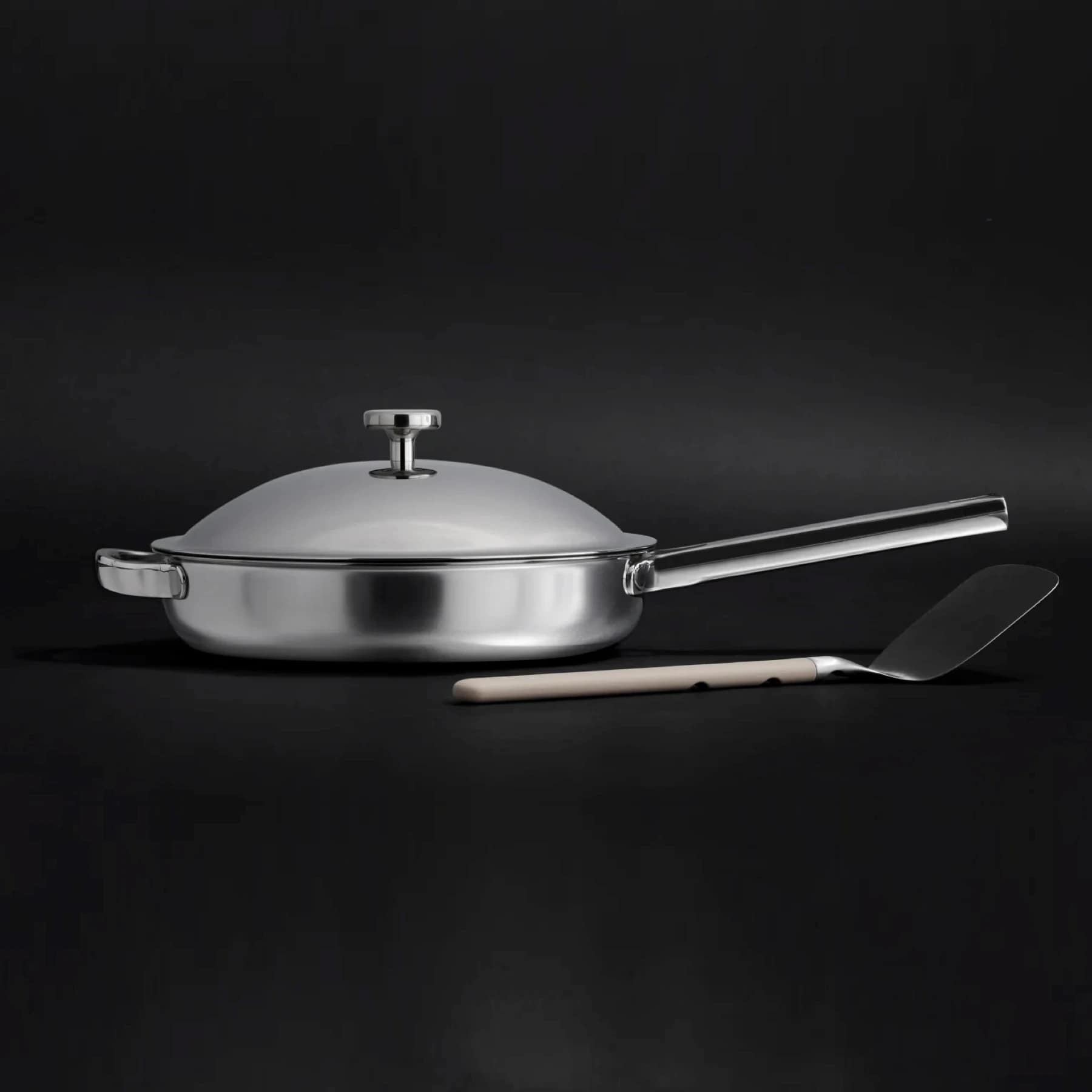 Our Place Titanium Always Pan Pro with lid and spatula on a kitchen counter
