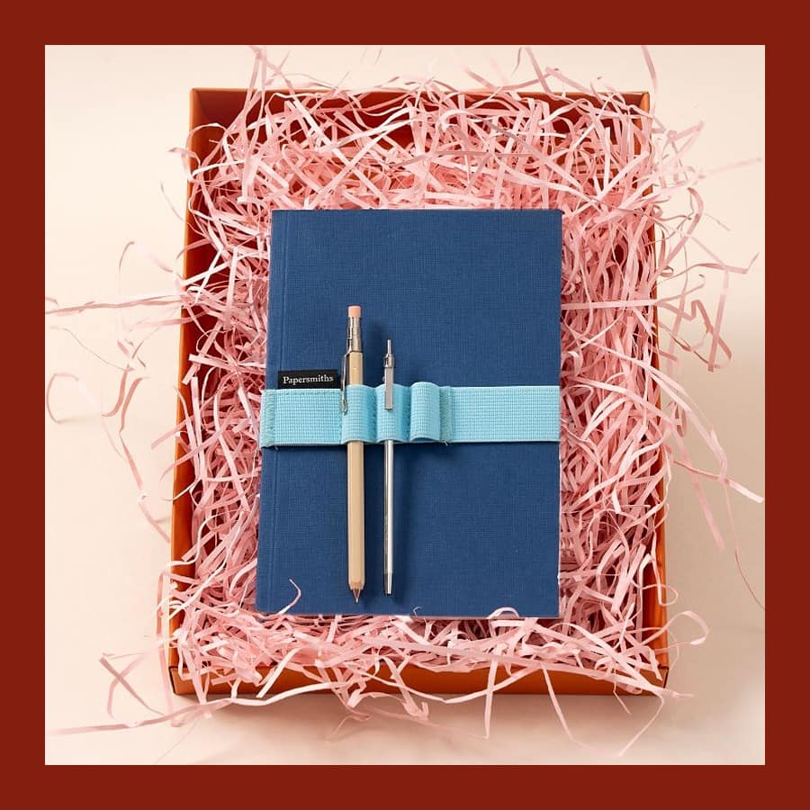 Papersmiths Travellers Gift Set with a blue notebook, pen and pencil in pink shredded paper