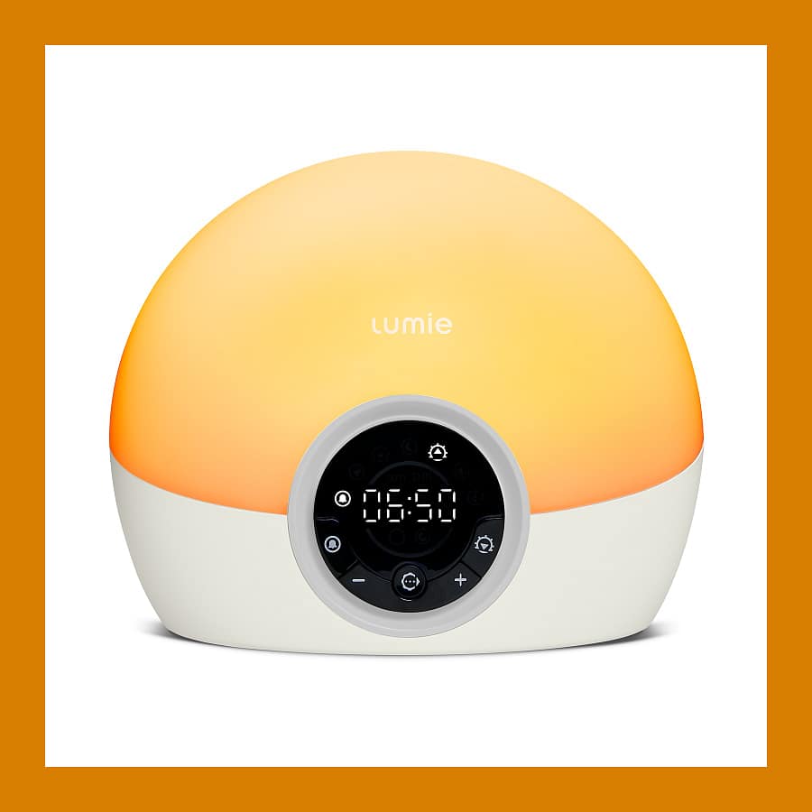 Lumie Bodyclock Spark 100 wake-up light glowing orange with a round display