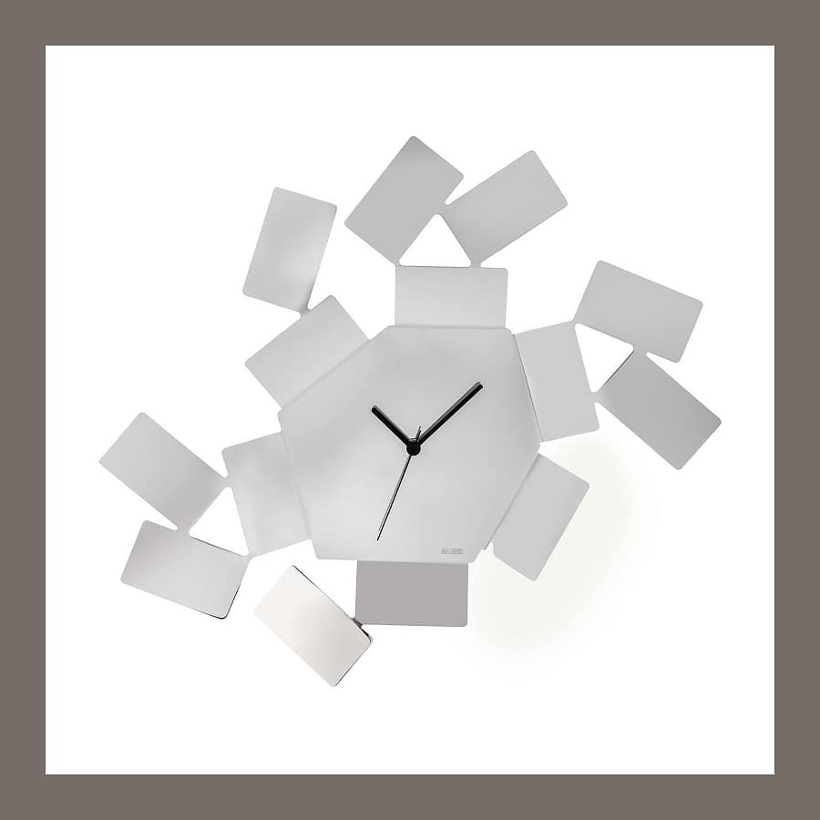 Alessi La Stanza dello Scirocco wall clock in polished steel, a hexagonal face surrounded by scattered steel tiles