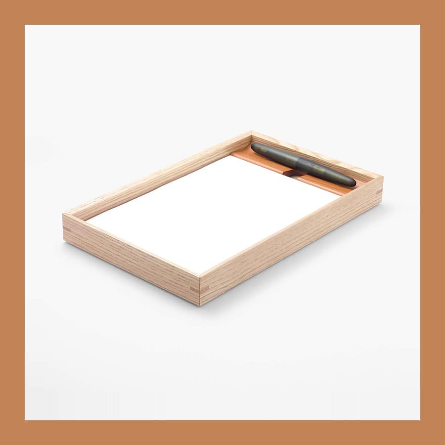 Kakimori A5 wooden writing tray in chestnut with a cherry pen rest holding a pen