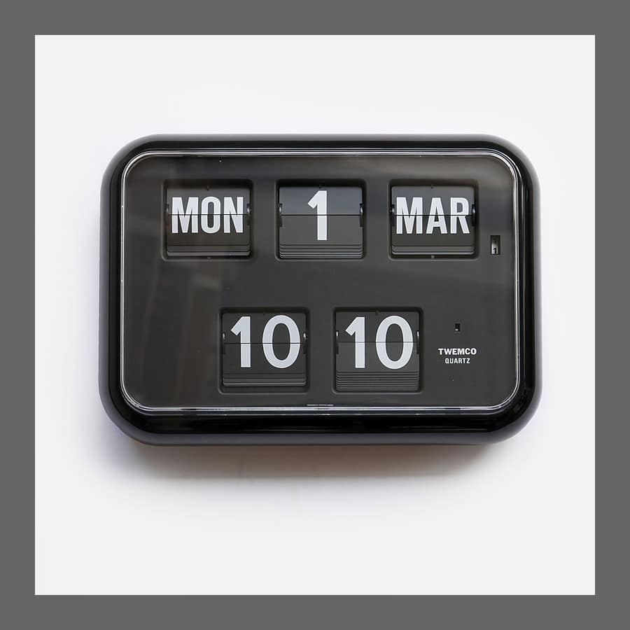 Black 24 hour flip clock and calendar showing Mon 1 Mar 10:10