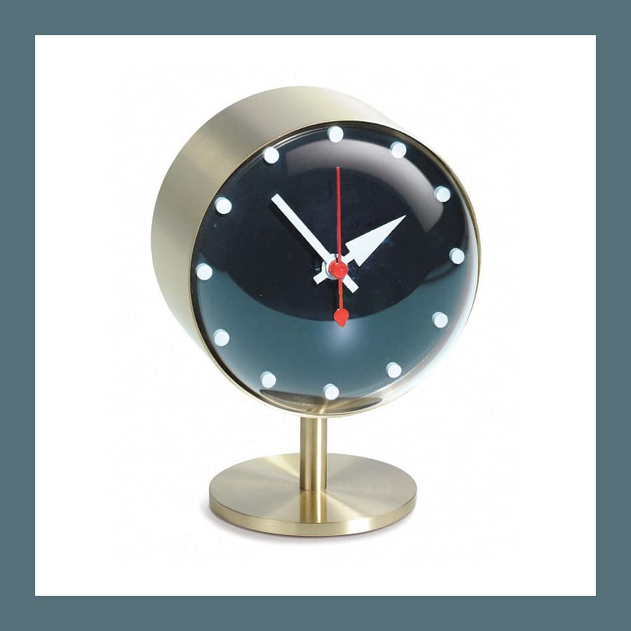 Vitra Night Clock by George Nelson with a brass case, black face and white dot markers on a brass stand