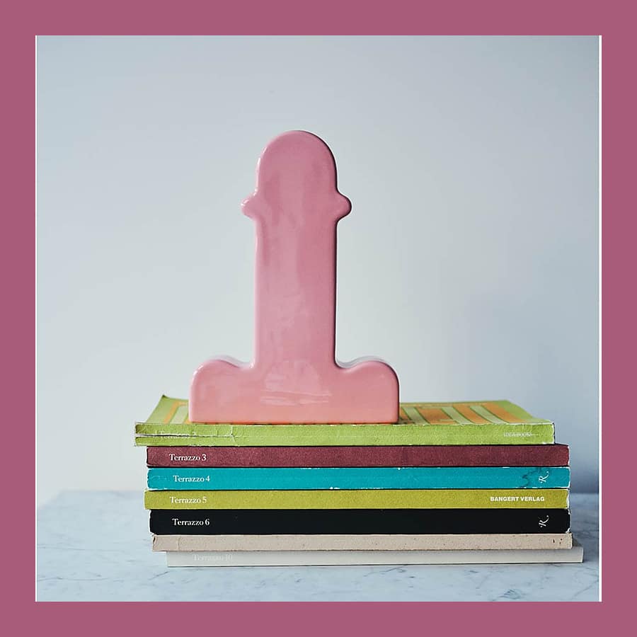 Pink glazed ceramic Shiva Flower Vase by Ettore Sottsass standing on a stack of Terrazzo journals on a marble shelf