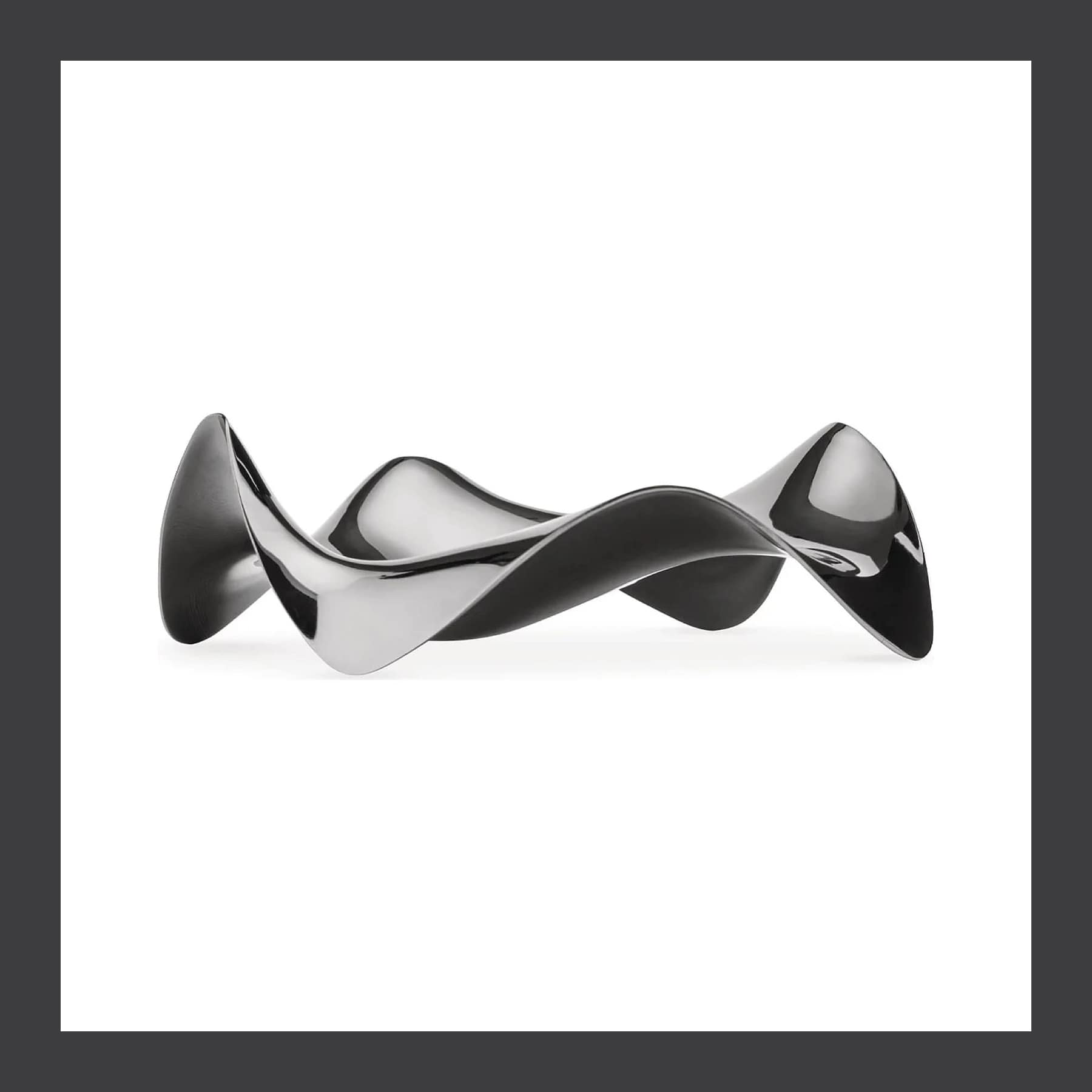 Alessi Blip spoon rest, a wave-shaped piece of mirror-polished stainless steel, on a white background