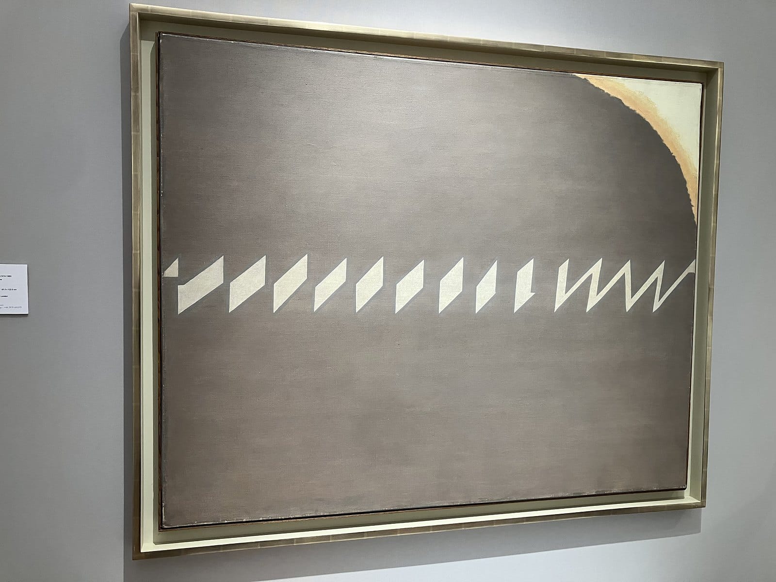 Prunella Clough grey canvas crossed by a horizontal band of white zigzag shapes, in a pale frame