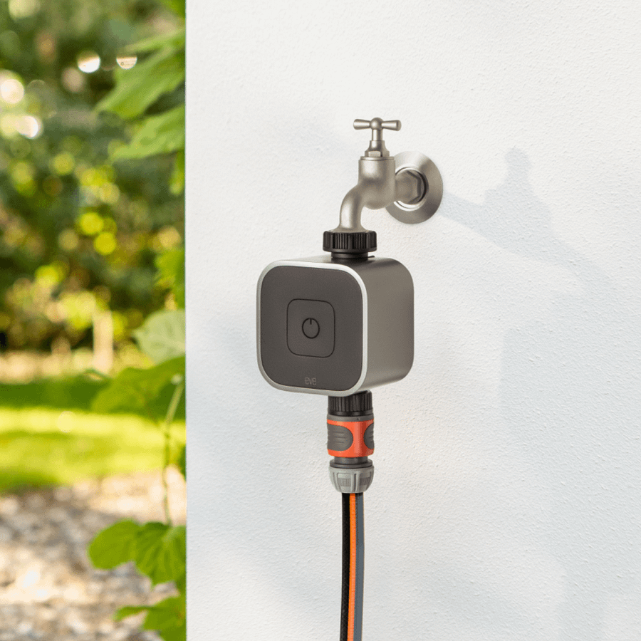 Eve Aqua smart tap timer fitted between a UK outdoor tap and a garden hose connector