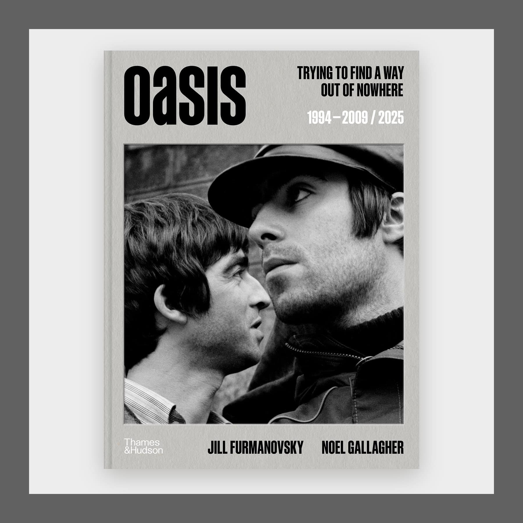 Grey cover of Oasis with a black and white photo of Noel and Liam Gallagher, in a grey frame