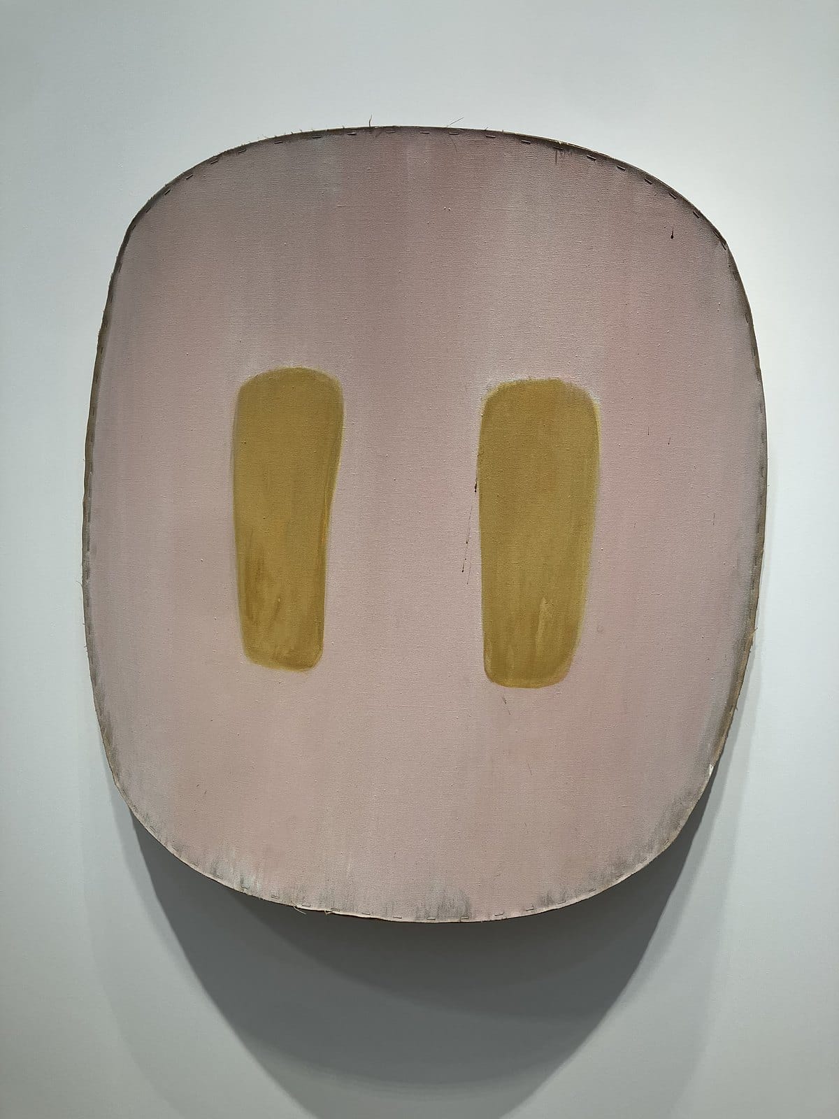 Ron Gorchov's curved pale pink canvas with two ochre vertical marks, hung on a white wall