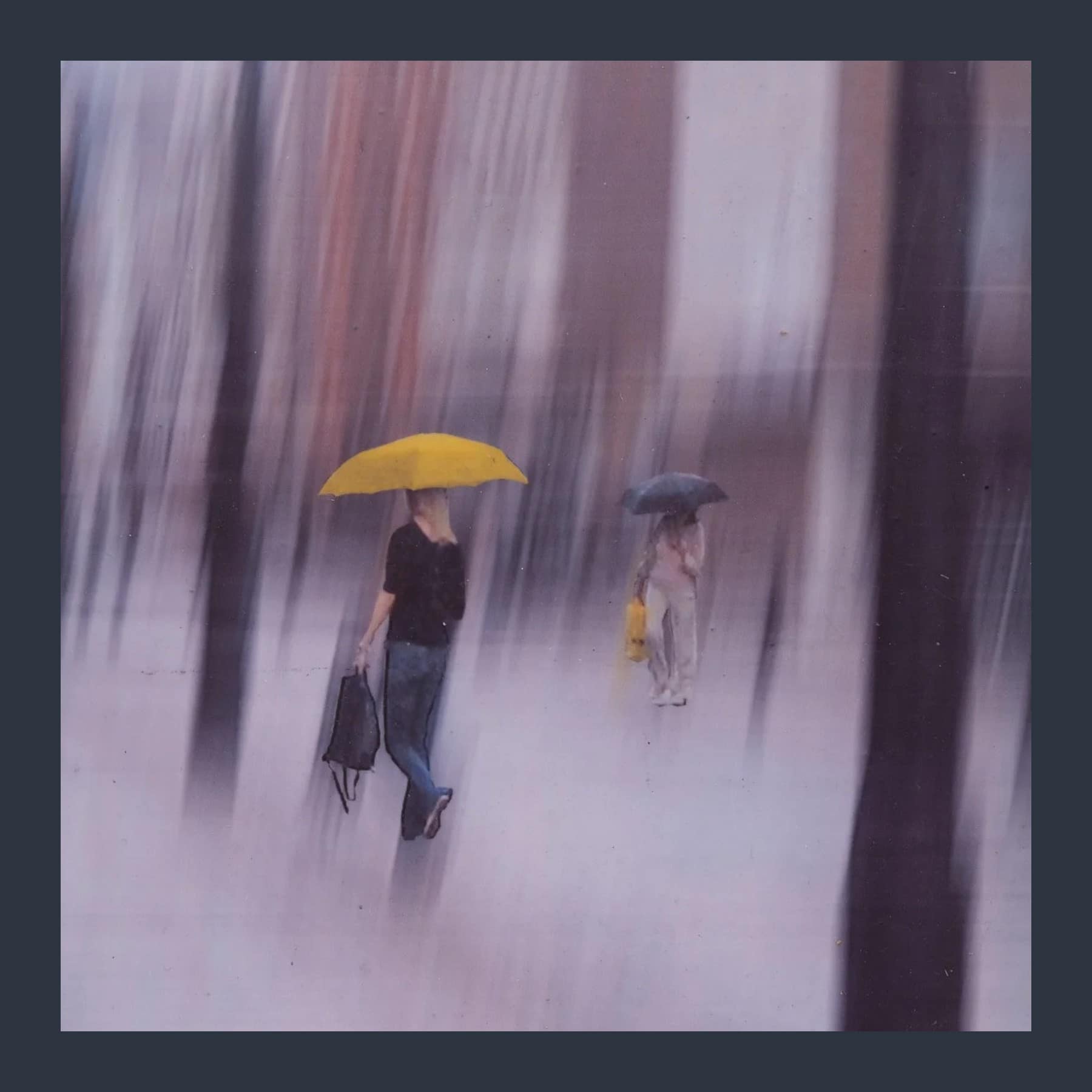 Blurred rainy street scene by David Rhys Jones, with a woman under a yellow umbrella and another under a dark umbrella