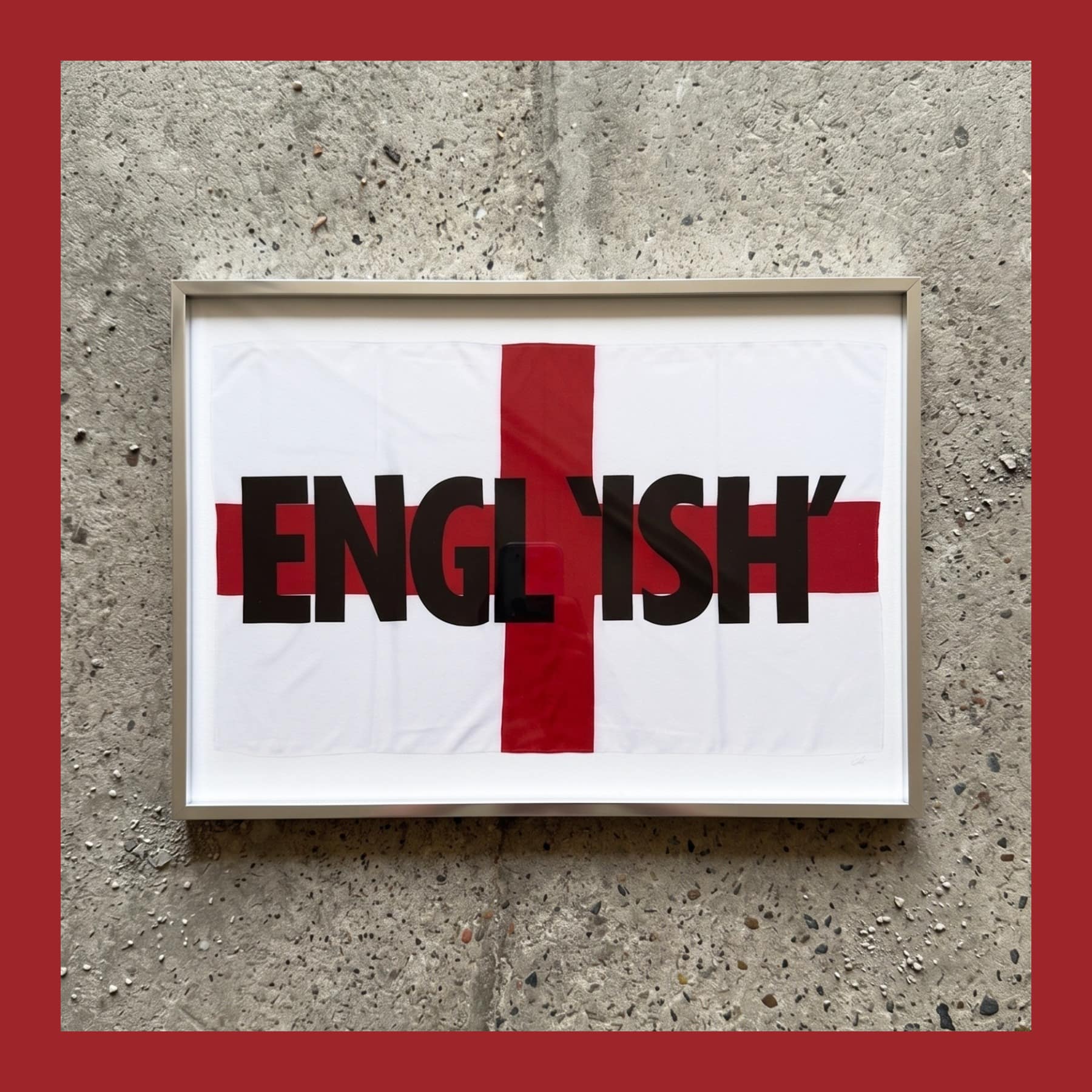 Corbin Shaw ENGL'ISH' print, a St George's cross with black lettering, in a metal frame on a concrete wall