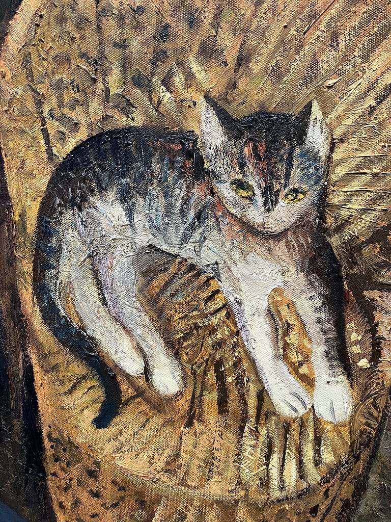 Detail of a tabby and white kitten painted lying in a wicker chair