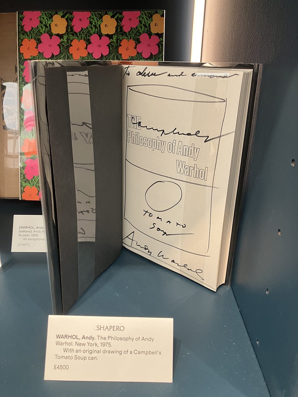 Open copy of The Philosophy of Andy Warhol with a hand-drawn Campbell's Tomato Soup can and signature