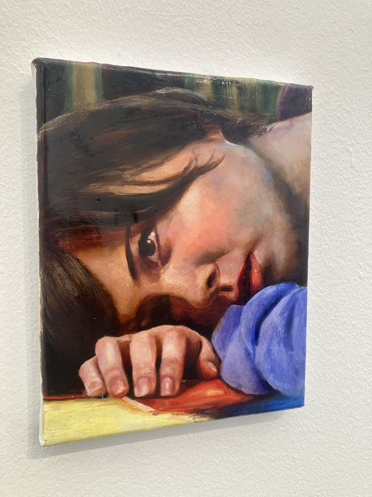 Small painting of a girl resting her head on her arm by Annabelle Agbo Godeau