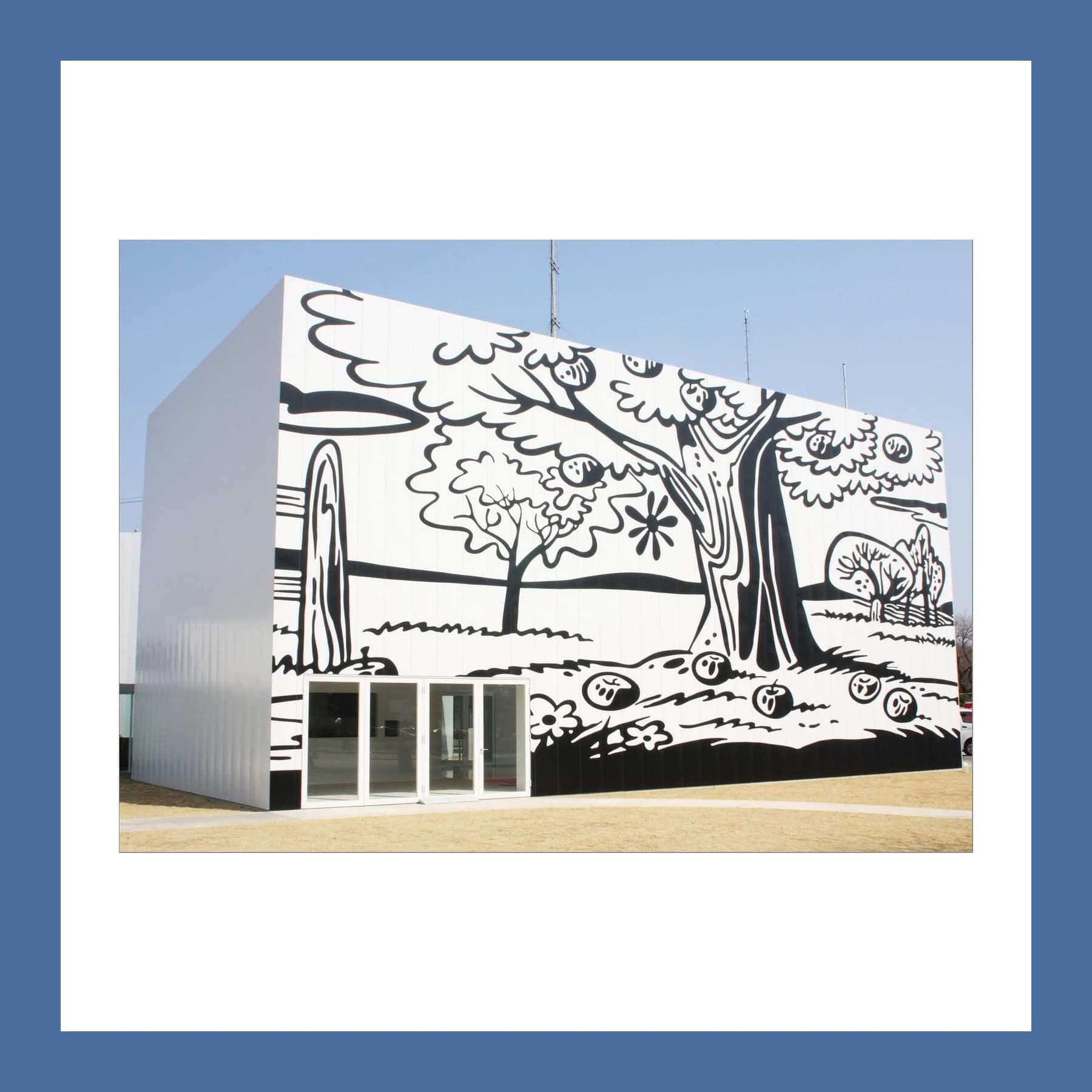White gallery building covered in a black-and-white mural of trees, flowers and hills