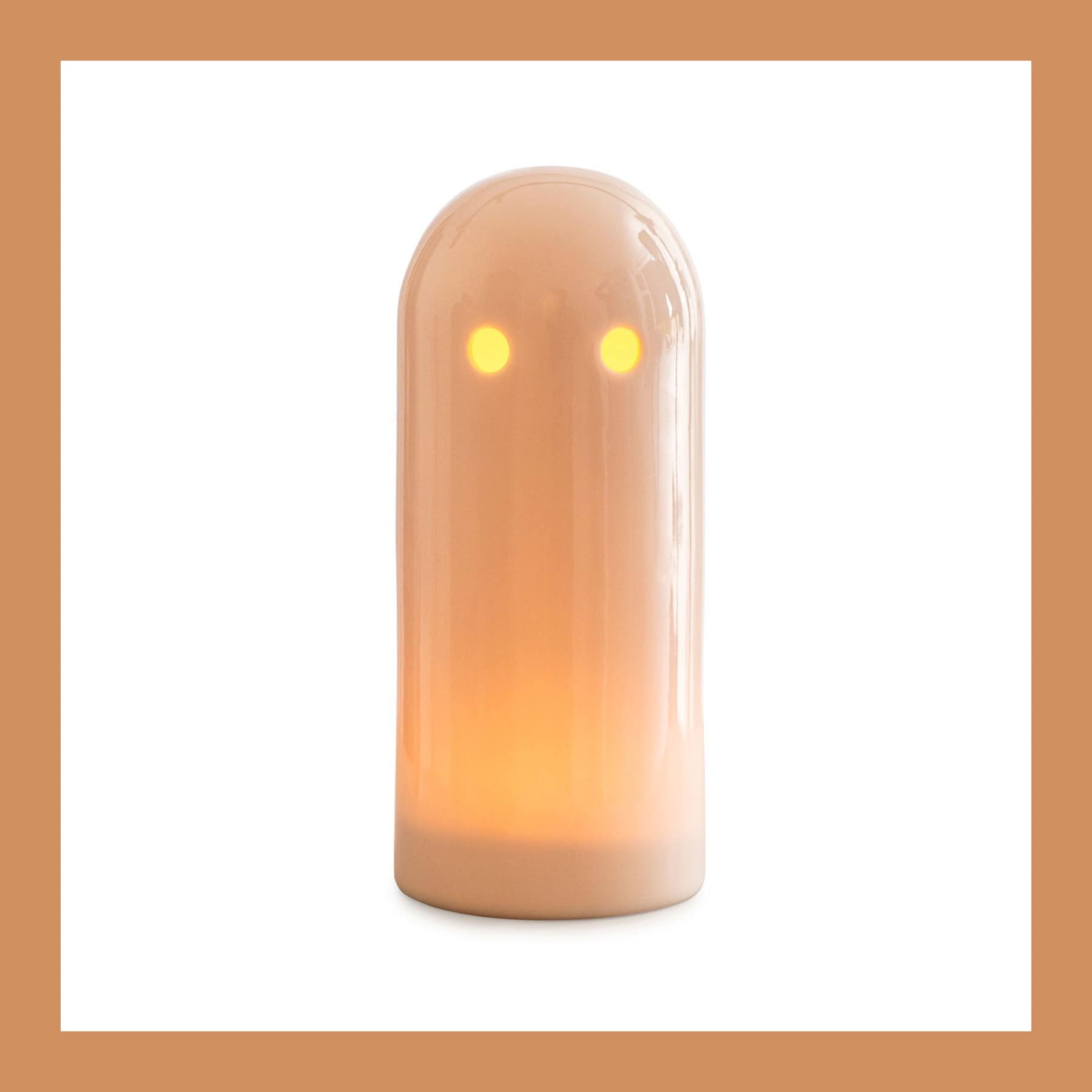 Studio Arhoj Ghost Light, a white porcelain ghost glowing orange from a tea light inside