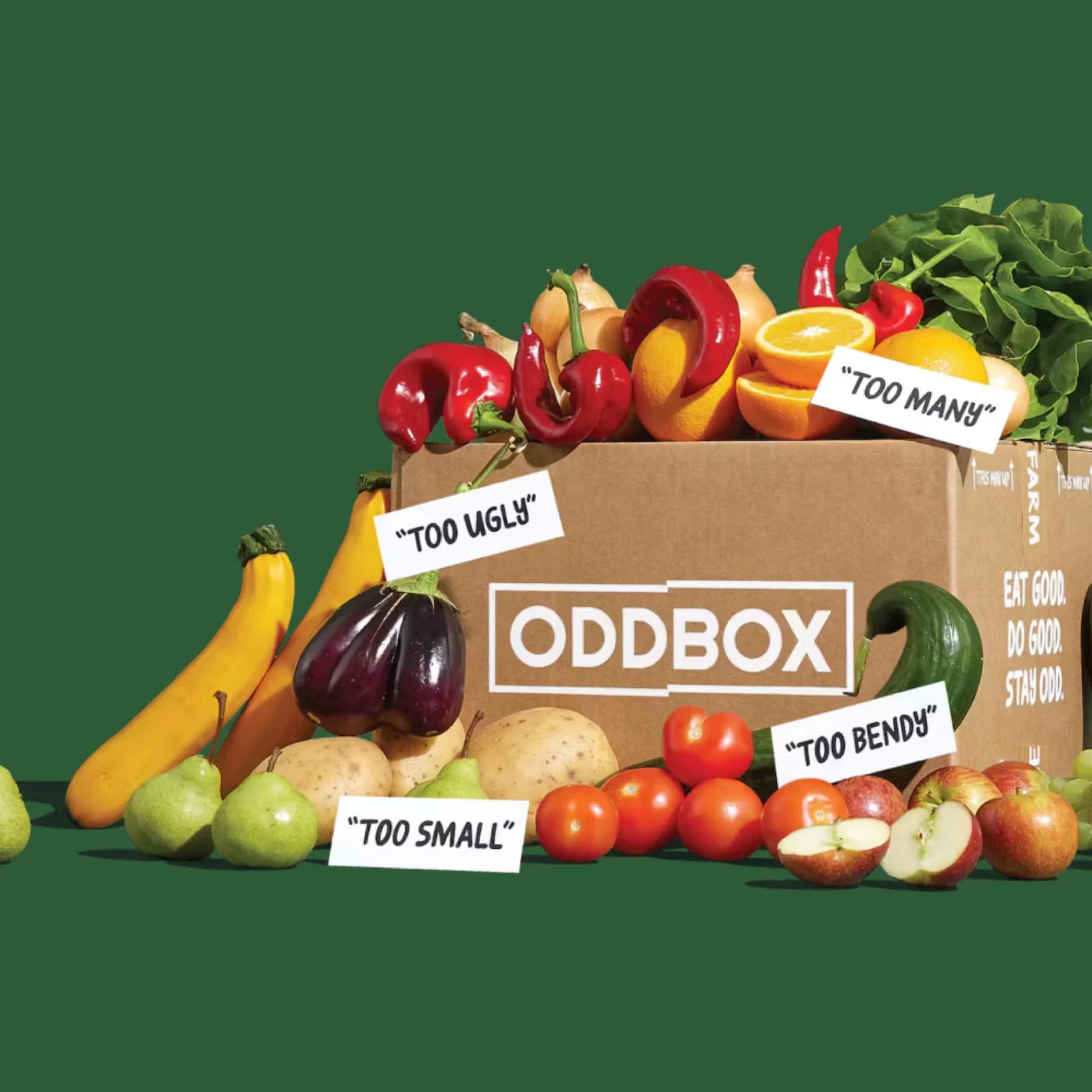 A cardboard Oddbox filled with colourful fruit and veg labelled “too ugly”, “too small”, “too bendy”, and “too many” on a green background, promoting Oddbox food waste boxes.