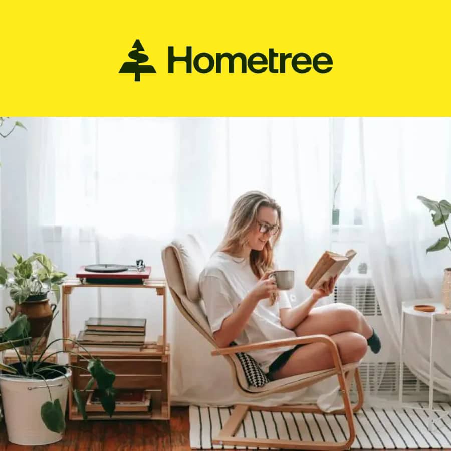 Woman reading and drinking coffee in a bright living room with Hometree logo