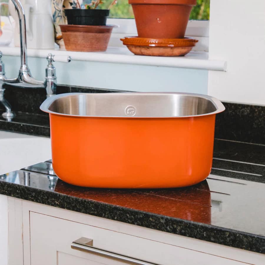 Elephant Box orange stainless steel washing up bowl on a black kitchen worktop