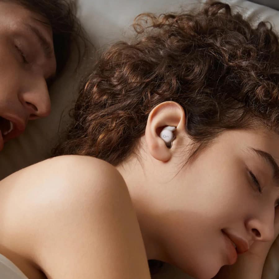 Woman peacefully sleeping with Soundcore Sleep A20 Sleepbuds, blocking snoring noise.
