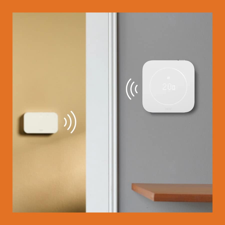 tado Smart Thermostat X on a grey wall linked wirelessly to the receiver in the boiler room