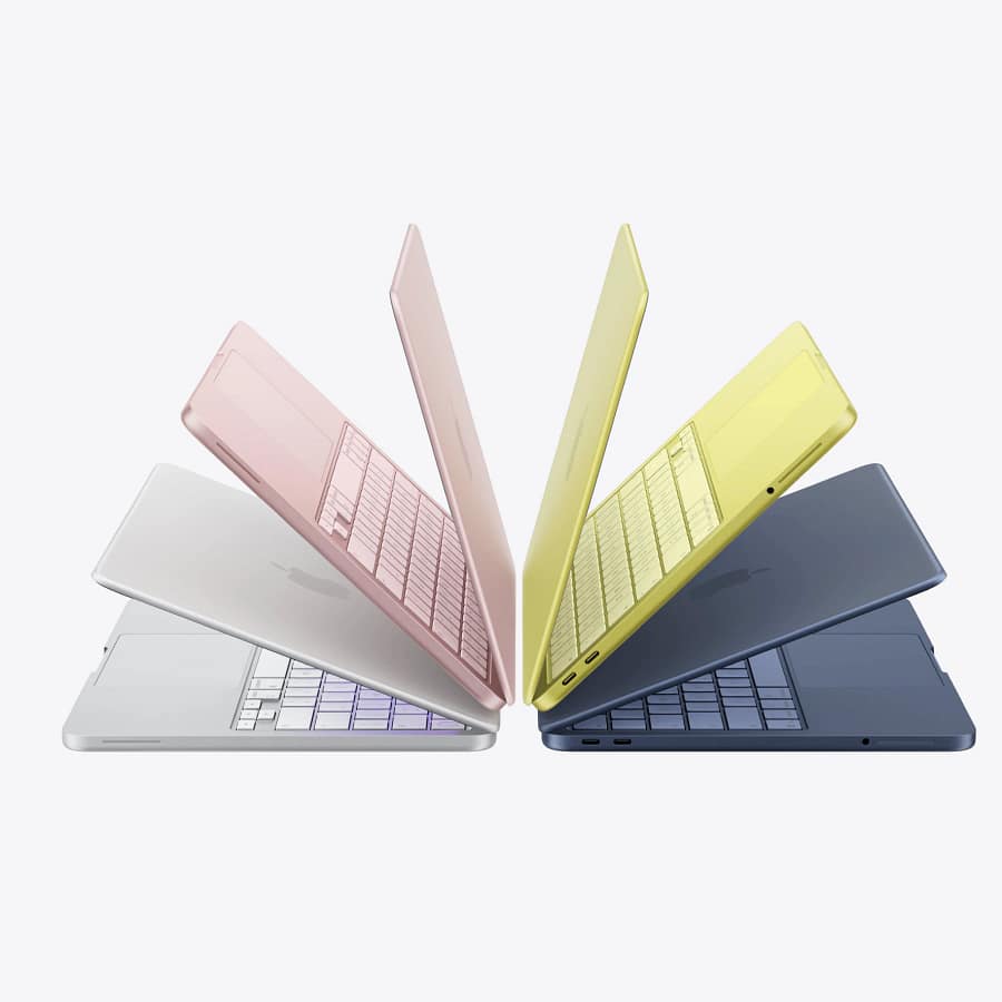 Four MacBook Neo laptops fanned open showing all colour options: Silver, Blush, Citrus, and Indigo with matching keyboards.