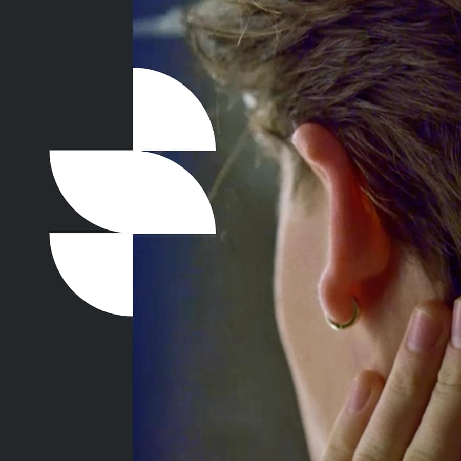 Close-up of man touching hair near ear with CoolCuration logo overlay