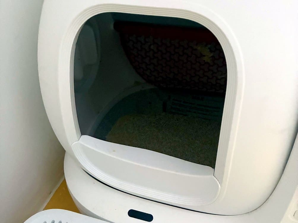 Interior of a PETKIT self-cleaning litter tray showing the honeycomb cylinder mat and clumping litter